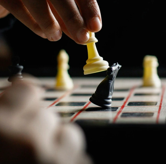 person holding white chess piece